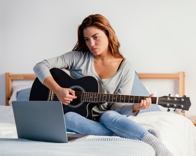 Mulher tocando violão para fazer streaming