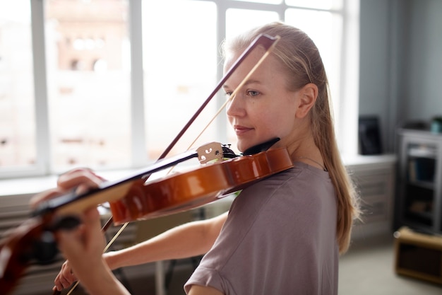 Foto grátis mulher tocando violino tiro médio