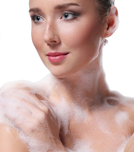 Mulher tomando banho com sabão no corpo e na cabeça. Conceito de higiene e cuidados com a pele