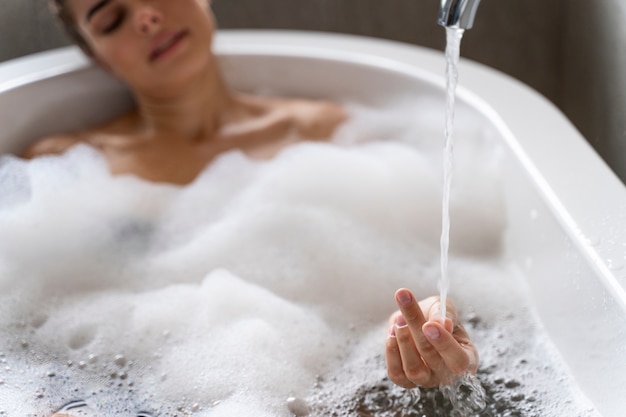 Mulher tomando banho de espuma relaxante