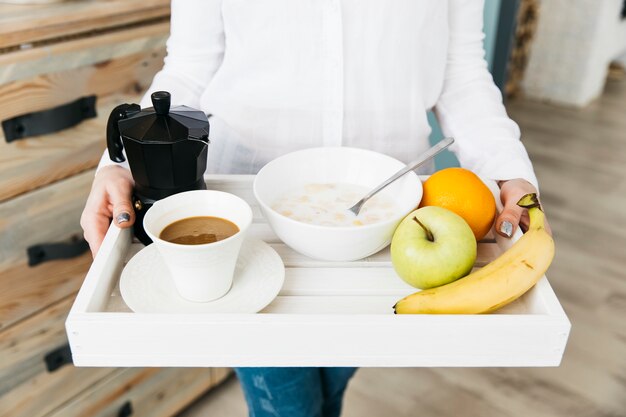 Mulher tomando café da manhã na cozinha