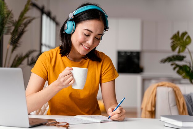 Mulher tomando café enquanto participava de uma aula online