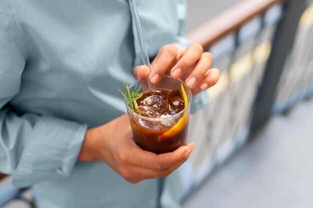 Mulher tomando um café gelado lá fora