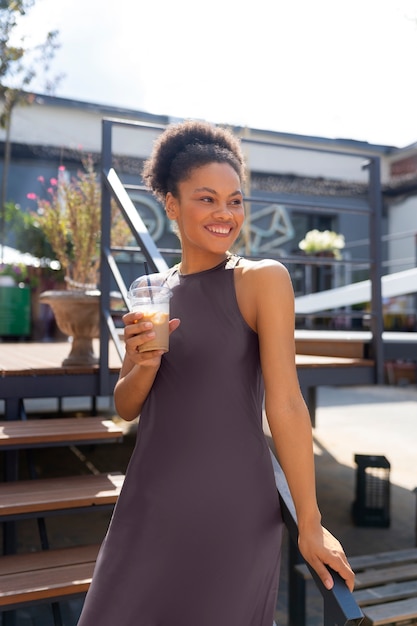 Foto grátis mulher tomando um café gelado lá fora