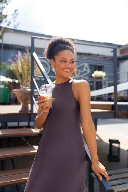 Mulher tomando um café gelado lá fora