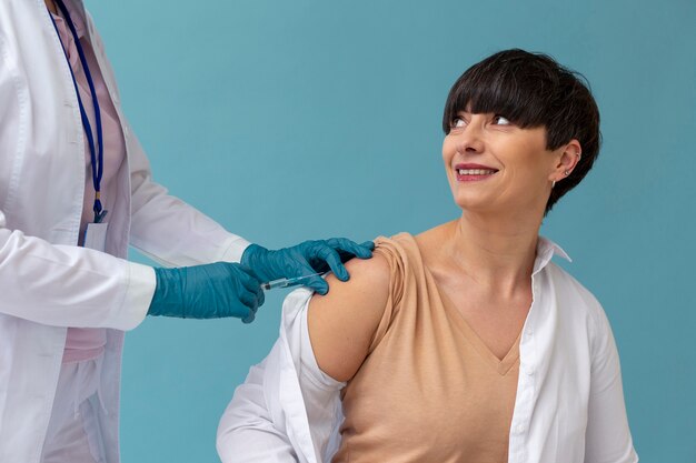 Mulher tomando vacina de perto