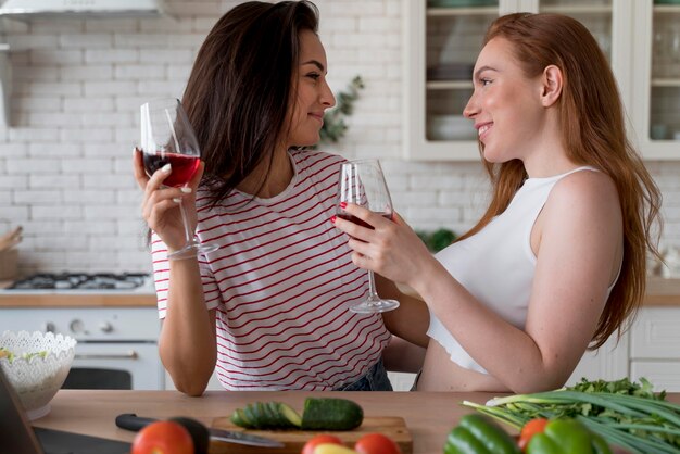 Mulher tomando vinho enquanto cozinha