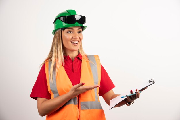 Mulher trabalhadora sorridente, usando óculos e uniforme de segurança