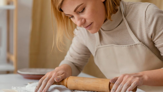 Mulher trabalhando com rolo de massa