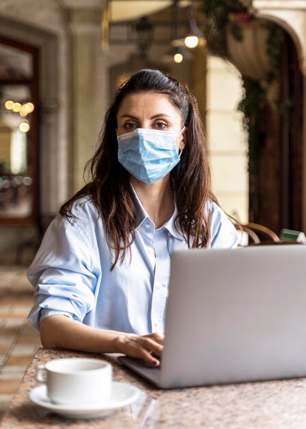 Foto grátis mulher trabalhando em ambientes fechados usando uma máscara facial