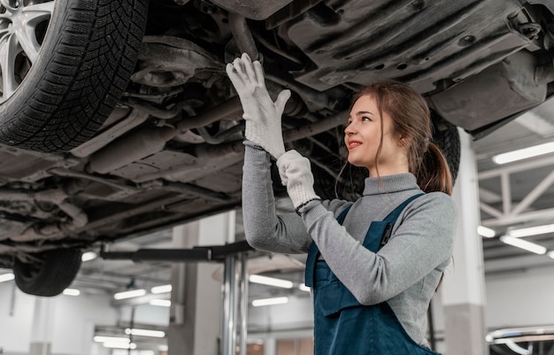 Foto grátis mulher trabalhando em uma oficina de automóveis