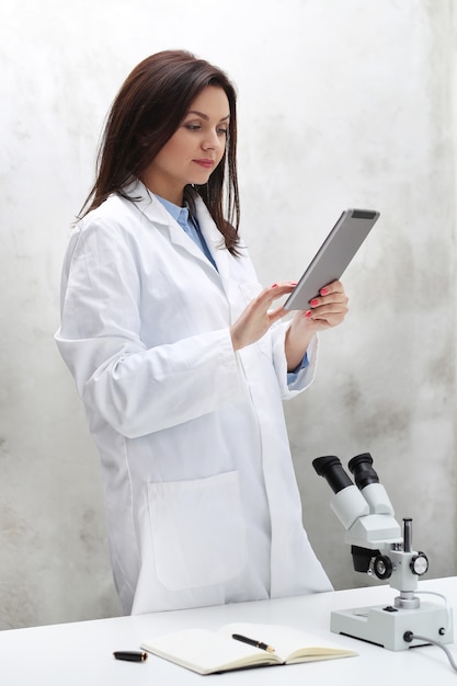 Foto grátis mulher trabalhando no laboratório com um microscópio