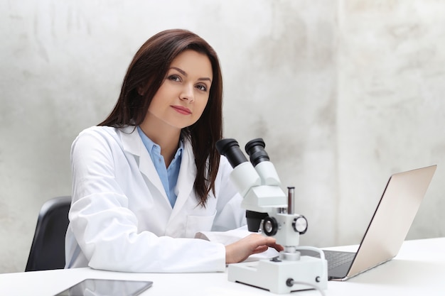 Mulher trabalhando no laboratório com um microscópio