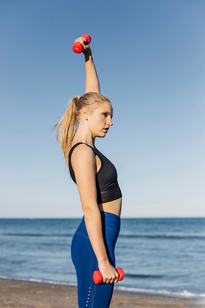 Mulher, treinamento, com, dumbbells, praia