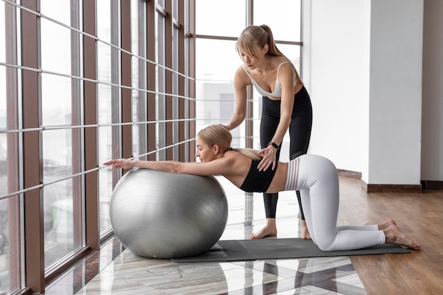 Mulher treinando com bola e tapete