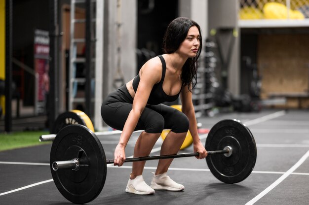 Mulher treinando com halterofilismo