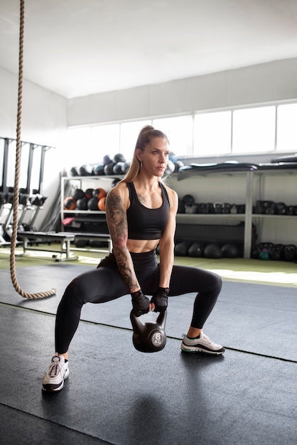 Mulher treinando com kettlebell tiro completo