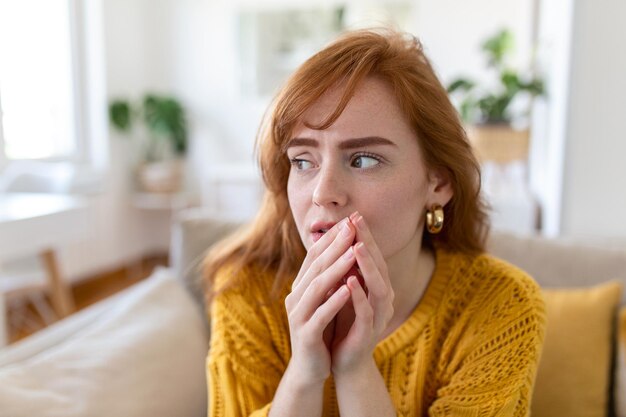 Mulher triste sente-se miserável, desesperada, sente-se no sofá, olhe pela janela, pensando em problemas pessoais, não vê saída para uma situação de vida difícil.