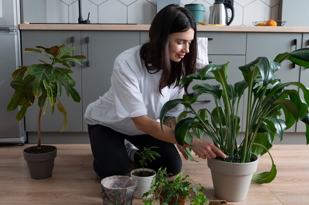 Mulher trocando os vasos de suas plantas em casa durante a quarentena
