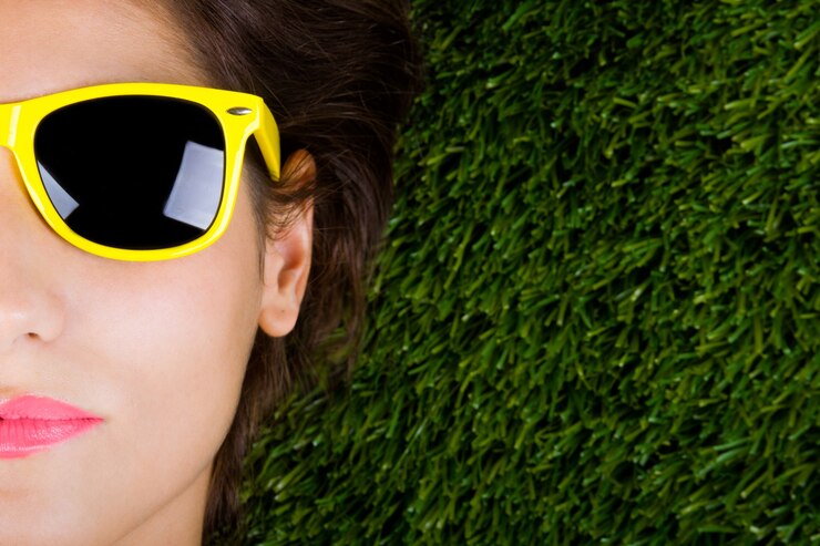 Foto grátis mulher tumbada sobre a hierba com gafas de sol
