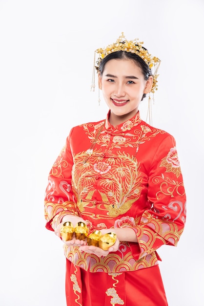 Mulher usa terno Cheongsam dá ouro para a família dela dar sorte no ano novo chinês