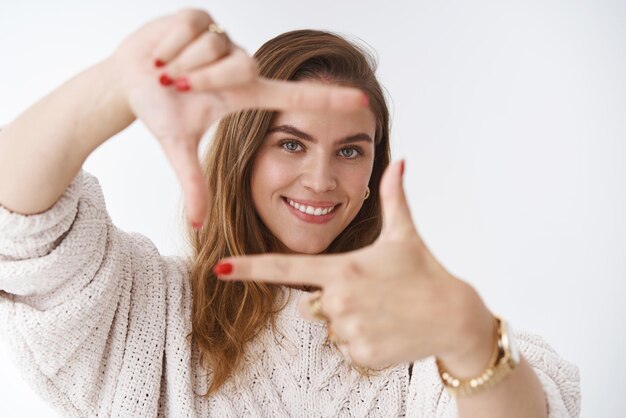 mulher usando a imaginação imaginando o novo design do apartamento como capturar você fazendo moldura de dedo olhando através de curioso encantado em pé divertido, feliz