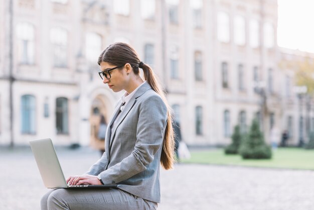 Mulher, usando computador portátil, em, cidade