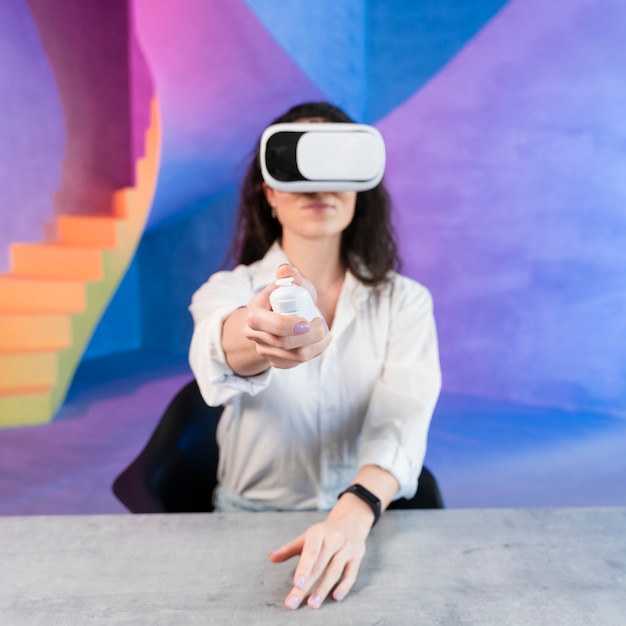 Mulher usando fone de ouvido de realidade virtual e segurando um controle remoto