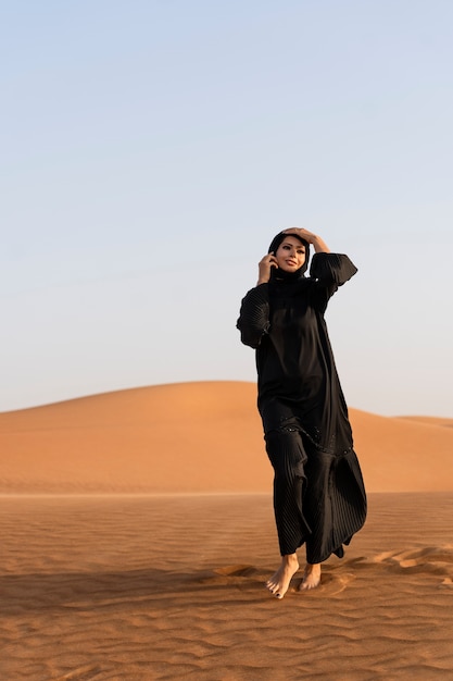 Mulher usando hijab no deserto