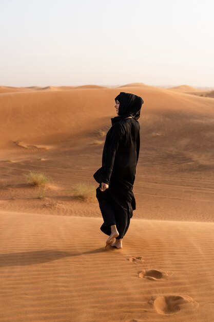 Mulher usando hijab no deserto