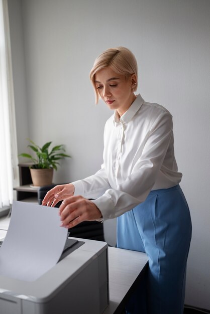 Mulher usando impressora enquanto trabalhava no escritório