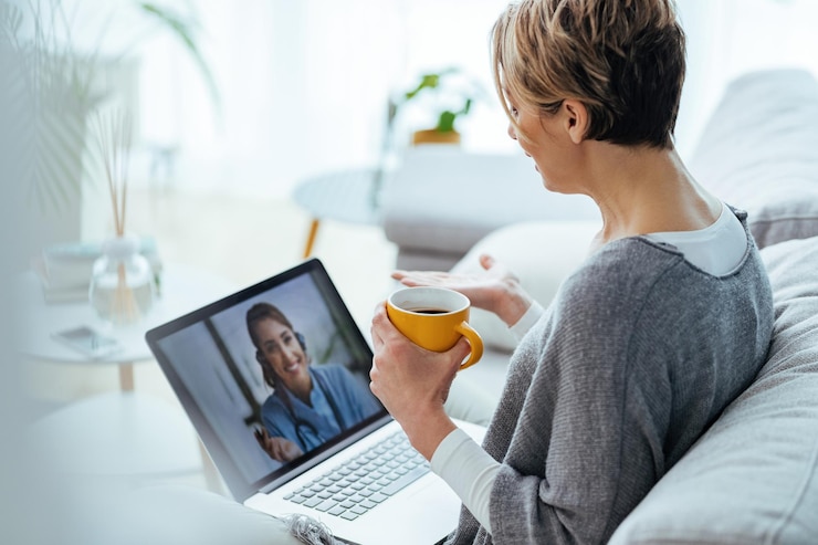 Foto grátis mulher usando laptop e fazendo videochamada com seu médico enquanto está sentado em casa