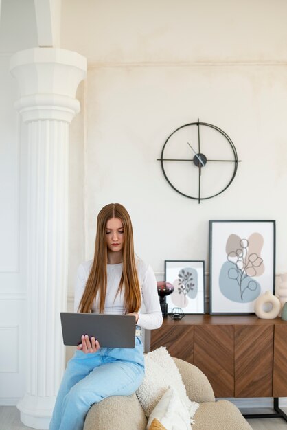 Mulher usando laptop em quarto decorado mínimo