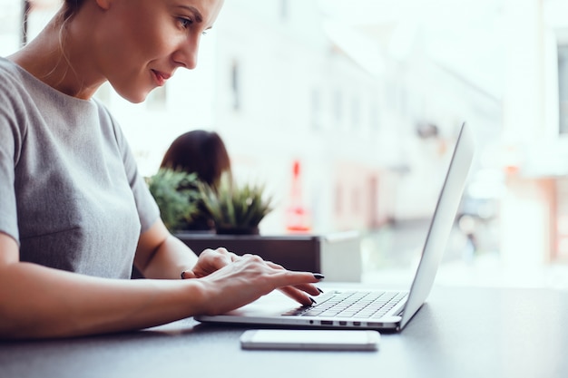 Mulher usando laptop em um café