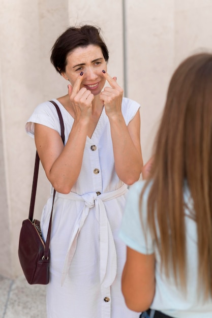 Mulher usando linguagem de sinais para transmitir choro à amiga