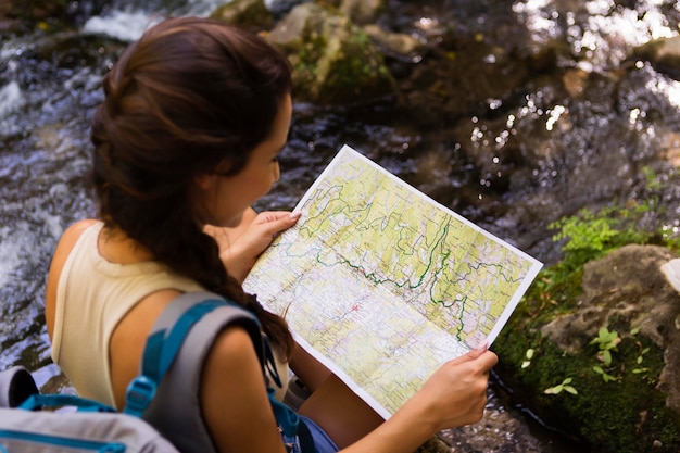 Foto grátis mulher usando mapa para explorar a natureza