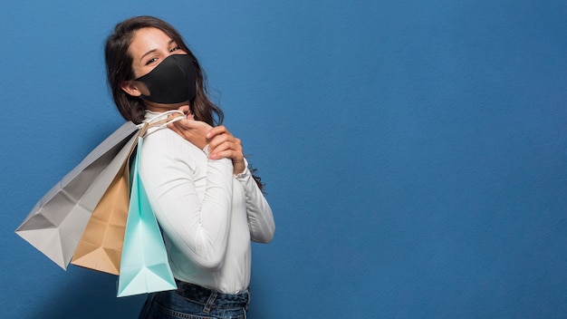 Foto grátis mulher usando máscara e segurando sacolas de compras