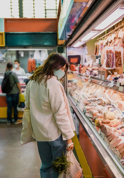 Mulher usando máscara facial no mercado