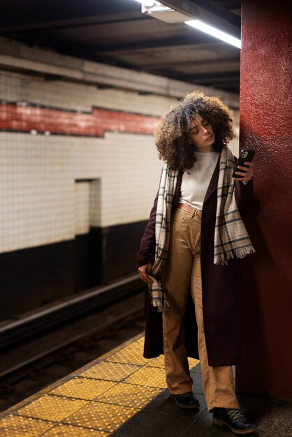 Mulher usando smartphone enquanto viaja com o metrô na cidade