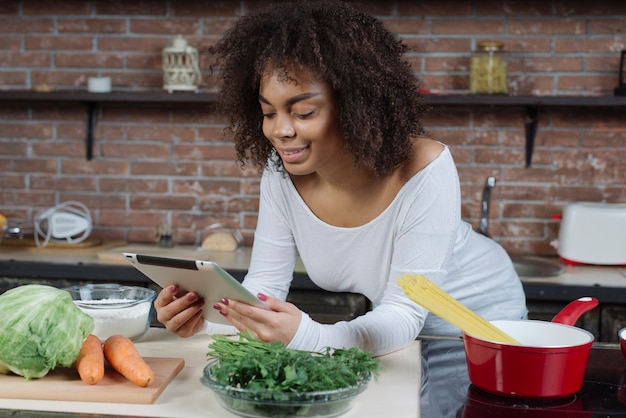 Mulher usando tableta na cozinha