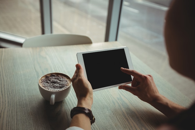 Mulher, usando, tablete digital, enquanto, tendo, xícara café
