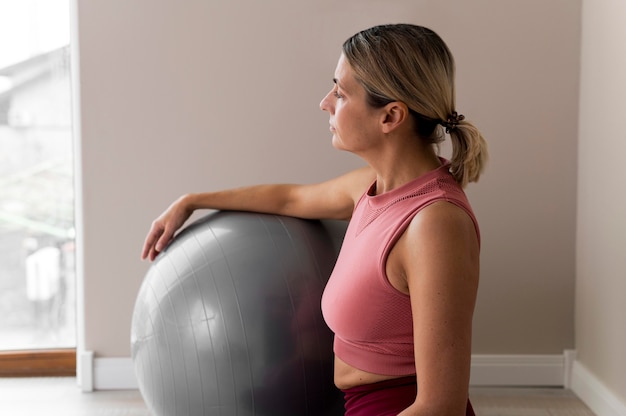 Mulher usando uma bola de fitness para seu treino