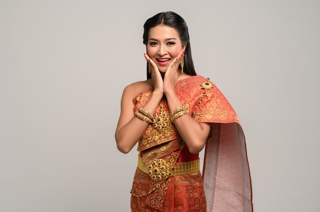 Mulher usando vestido tailandês que fez um símbolo de mão