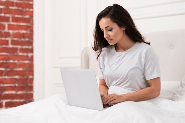 Mulher verificando seu laptop depois de acordar