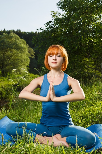 Mulher vermelha meditando ao ar livre