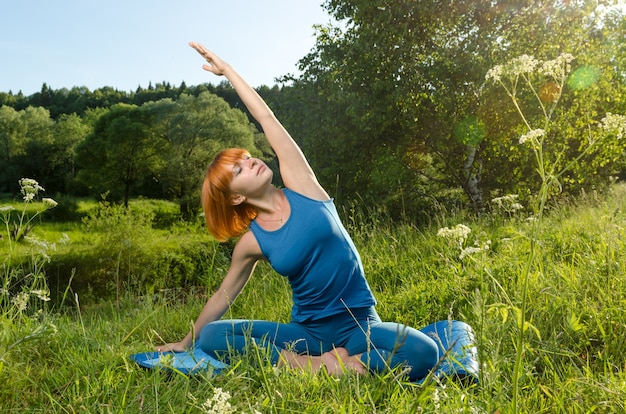 Mulher vermelha praticando fitness yoga ao ar livre