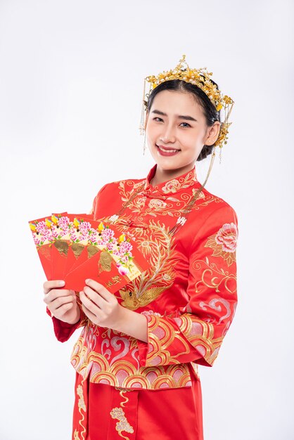 Mulher vestindo terno Cheongsam tem muita sorte de receber dinheiro de presente dos pais nos dias tradicionais