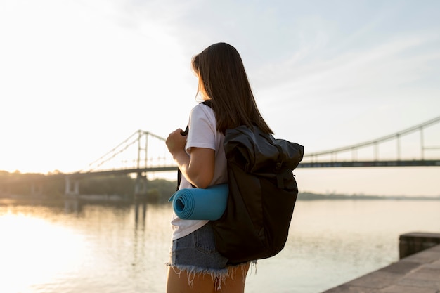 Foto grátis mulher viajando com mochila admirando a vista do rio