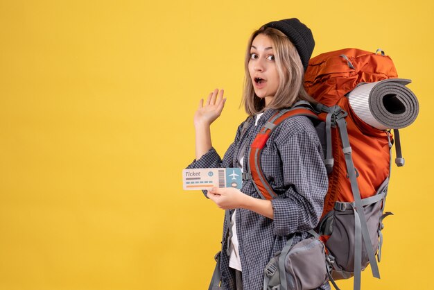 mulher viajante com mochila segurando bilhete mostrando