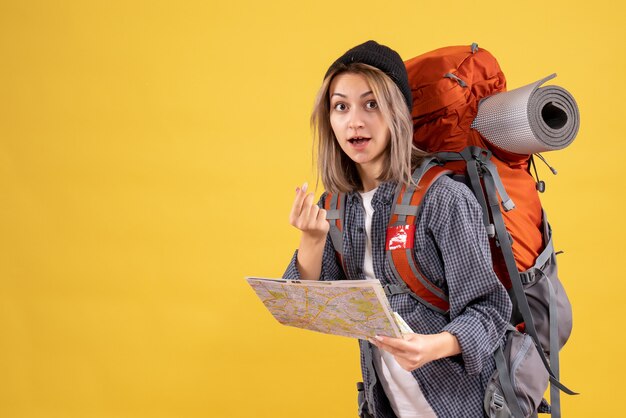 mulher viajante com mochila segurando mapa e fazendo cartaz de dinheiro